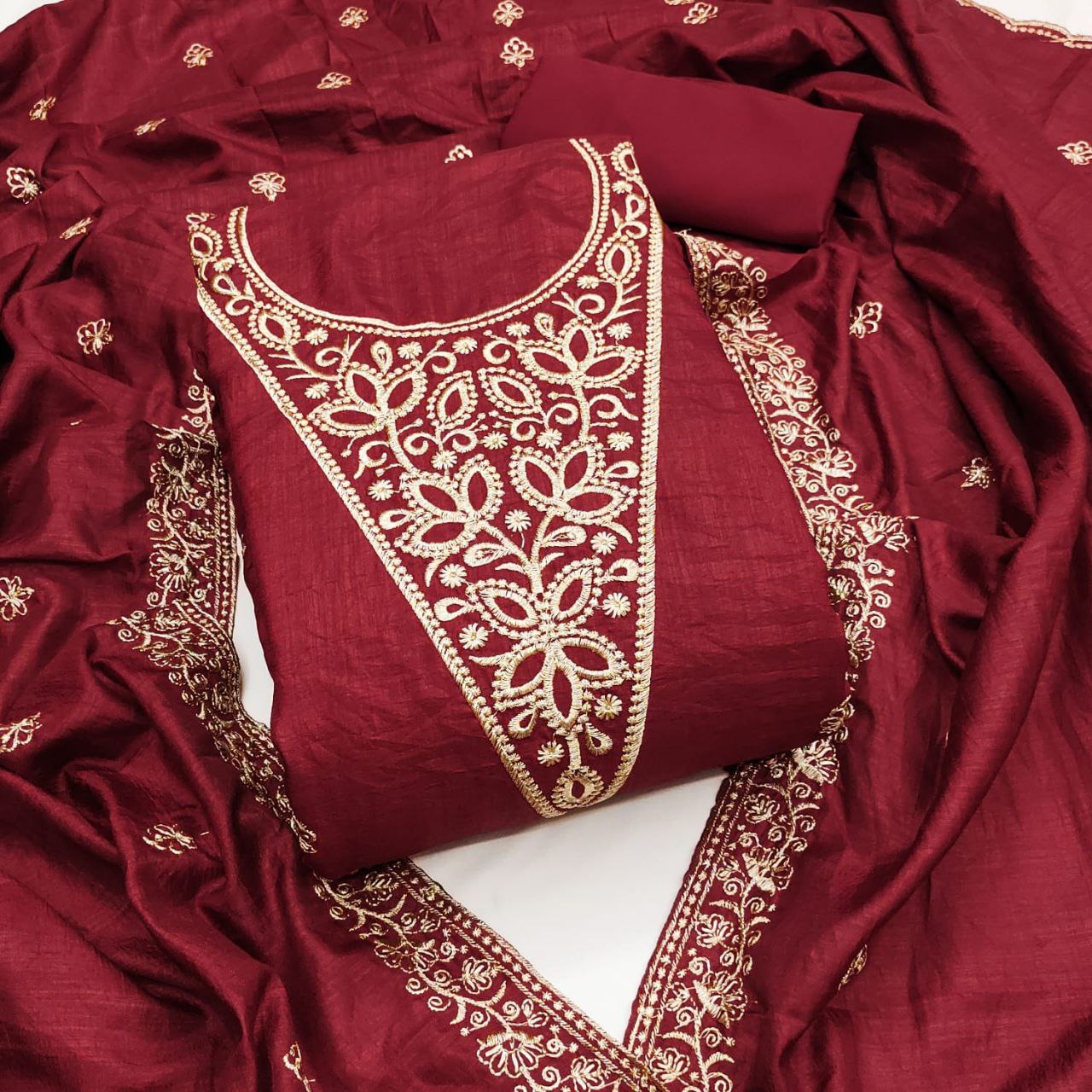 Red fabric with gold embroidery on a white background