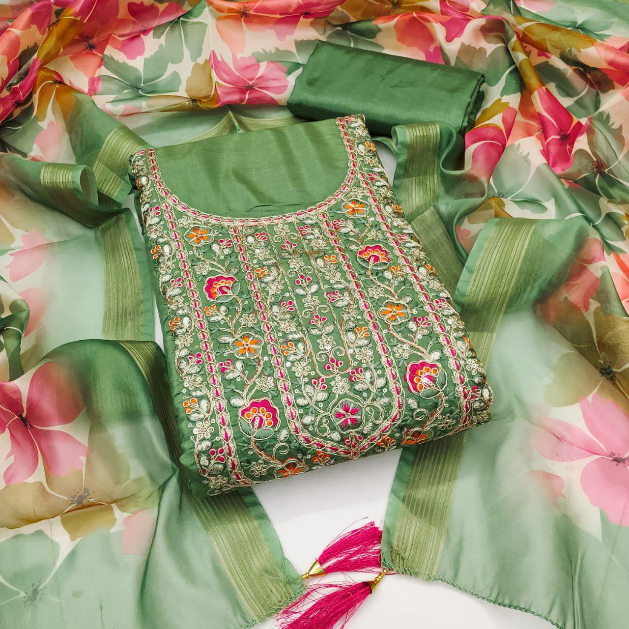 Green embroidered blouse with floral patterns on a floral fabric background