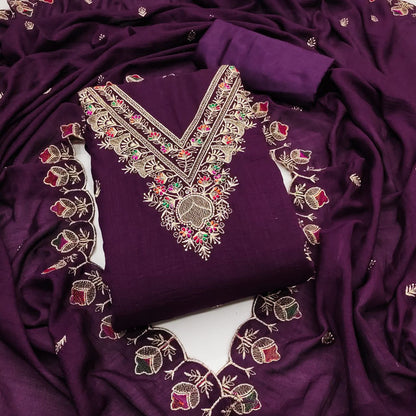 Purple fabric with intricate gold and multicolored embroidery on a white background